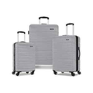 Three-piece hardside luggage set in titanium finish, including carry-on and larger expandable suitcases with integrated handles.