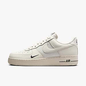 Nike Air Force 1 Low with premium leather upper and stitched mesh paneling, featuring perforated toe box and padded low-cut collar.