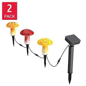 Three hand-blown artisan glass solar lights in red, orange, and yellow with solar charging panels on top.