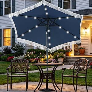 Navy blue 7.5 ft patio umbrella with white fringe tassels, solar panel mounted on top, and crank/tilt mechanism base.