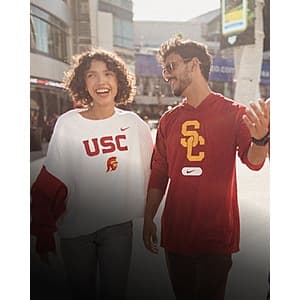Assortment of officially licensed sports merchandise including jerseys, t-shirts, sweatshirts, and hats from various sports teams on display.