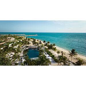 SLS Playa Mujeres beachfront resort in Cancun with oceanview pools, palm trees, and modern architecture along the coastline.
