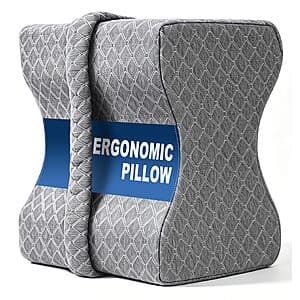Contoured knee and leg pillow in light color, designed for side sleeper support and spinal alignment.