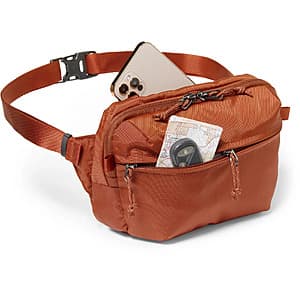 Iron oxide-colored REI Co-op Ruckpack waist pack with carry strap and zippered compartments.