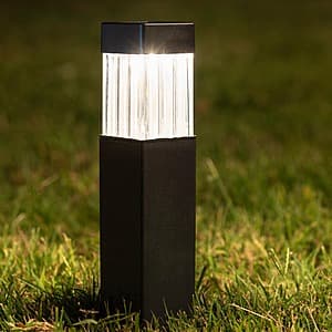 Matte black solar LED path light with 5-lumens output and built-in dusk-to-dawn sensor for outdoor landscaping.
