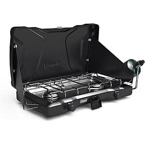 Coleman Triton 2-burner propane stove with adjustable burners and wind guards, displaying the cooktop surface and control knobs.