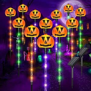 12 solar-powered pumpkin-shaped pathway stake lights with orange pumpkin design and green stems for outdoor Halloween decoration.