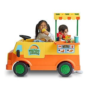 Colorful taco truck-themed 12V battery-powered ride-on vehicle for children with included accessories.