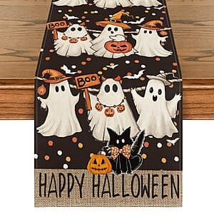 Halloween-themed table runner with printed ghost, jack-o'-lantern, and black cat designs on a seasonal background.