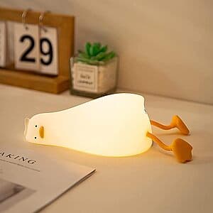 Yellow duck-shaped LED night light with a flat lying design and touch-control interface, shown in a lit state emitting soft light.