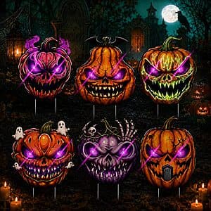 Six LED light-up orange pumpkin yard signs with green stakes arranged in a display.