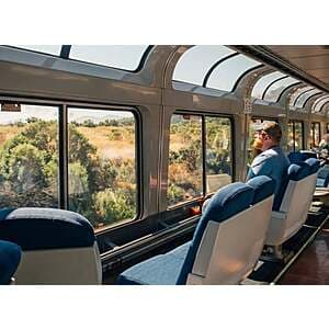 Amtrak passenger train traveling through scenic American landscape representing the Stars and Stripes Collection rail vacation program.